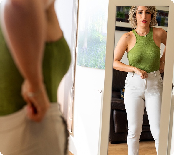 woman-checking-weight-loss-progress-in-mirror woman-checking-weight-loss-progress-in-mirror